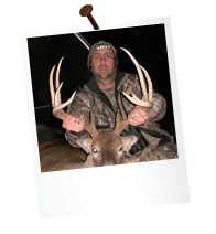 hunter in the dark holding antlers of a large deer in the back of a pickup truck