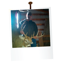 man in a bar holding a dead deer with large antlers