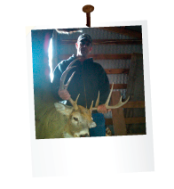 man in a bar holding a dead deer with large antlers
